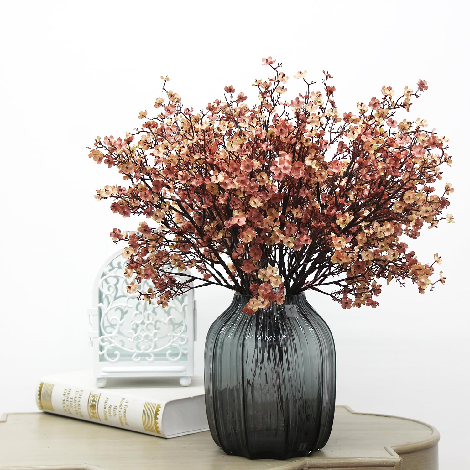 Beige, blush and brown faux stems arranged in a smoky glass vase